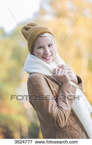 Portrait of a content pretty blonde woman with bonnet and scarf in Autumn smiling at camera View Large Photo Image Stock Photo - Portrait of a content pretty blonde woman with bonnet and scarf in Autumn smiling at camera. Fotosearch