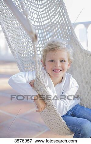 Stock Photo - Portrait of a cute boy in a hammock outdoors smiling at camera. Fotosearch