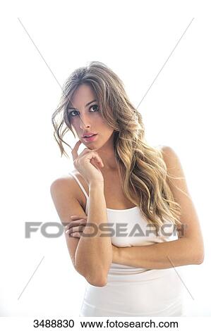 Stock Image - Portrait of a pensive woman with white background looking at camera. Fotosearch