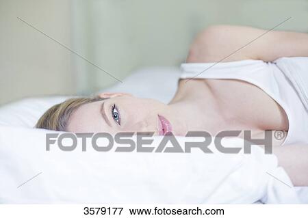 Portrait of a pretty blonde woman in bed looking at camera View Large Photo Image Stock Photo - Portrait of a pretty blonde woman in bed looking at camera. Fotosearch