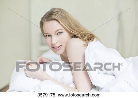 Portrait of a pretty blonde woman in bed looking at camera View Large Photo Image Stock Photo - Portrait of a pretty blonde woman in bed looking at camera. Fotosearch
