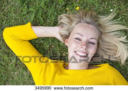 Portrait of a pretty blonde woman lying down in park smiling at camera View Large Photo Image Stock Image - Portrait of a pretty blonde woman lying down in park smiling at camera. Fotosearch