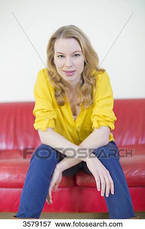 Portrait of a pretty blonde woman on the couch looking at camera View Large Photo Image Stock Photo - Portrait of a pretty blonde woman on the couch looking at camera. Fotosearch