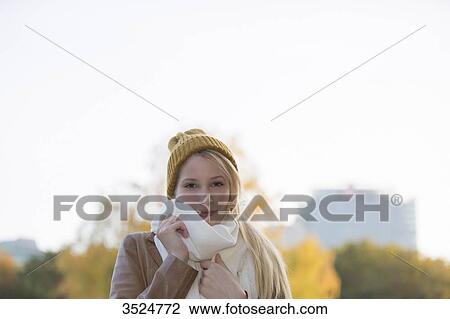 Stock Image - Portrait of a pretty blonde woman with bonnet and scarf in Autumn. Fotosearch