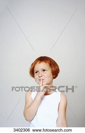 Portrait of a red-haired little girl indoors holding her finger in front of the mouth with an inquiring look on her face View Large Photo Image Stock Photograph - Portrait of a red-haired little girl indoors holding her finger in front of the mouth with an inquiring look on her face. Fotosearch