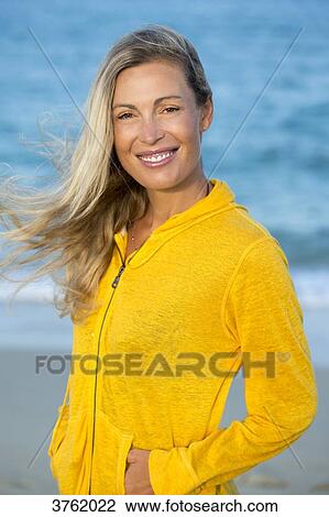 Portrait of a smiling young blonde woman in yellow sweet in the sea. View Large Photo Image Stock Image - Portrait of a smiling young blonde woman in yellow sweet in the sea.. Fotosearch