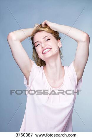 Portrait of a smiling young woman, arms over head View Large Photo Image Stock Photo - Portrait of a smiling young woman, arms over head. Fotosearch