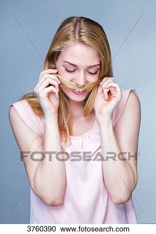 Portrait of a smiling young woman, hair in front of the mouth View Large Photo Image Stock Image - Portrait of a smiling young woman, hair in front of the mouth. Fotosearch