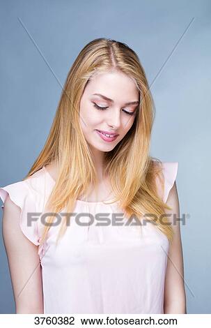 Portrait of a smiling young woman, head bent down View Large Photo Image Stock Image - Portrait of a smiling young woman, head bent down. Fotosearch