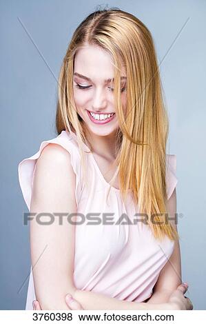 Portrait of a smiling young woman, head bent down View Large Photo Image Stock Photo - Portrait of a smiling young woman, head bent down. Fotosearch