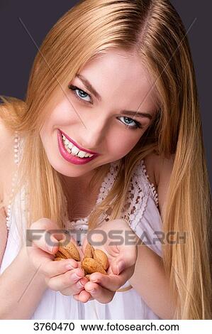 Portrait of a smiling young woman holding her hands almonds View Large Photo Image Stock Image - Portrait of a smiling young woman holding her hands almonds. Fotosearch