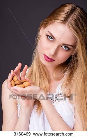 Portrait of a smiling young woman holding her hands almonds View Large Photo Image Stock Photo - Portrait of a smiling young woman holding her hands almonds. Fotosearch