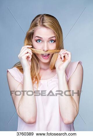 Portrait of a young astonished woman, hair in front of the mouth View Large Photo Image Stock Photo - Portrait of a young astonished woman, hair in front of the mouth. Fotosearch