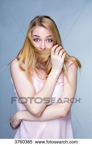 Portrait of a young astonished woman, hair in front of the mouth View Large Photo Image Stock Photography - Portrait of a young astonished woman, hair in front of the mouth. Fotosearch