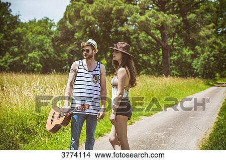 Portrait of a young couple Hipster ride in the countryside, a guitar in hand View Large Photo Image Picture - Portrait of a young couple Hipster ride in the countryside, a guitar in hand. Fotosearch