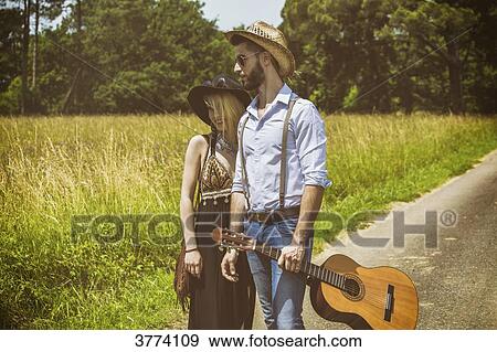 Portrait of a young couple Hipster ride in the countryside, a guitar in hand View Large Photo Image Stock Photo - Portrait of a young couple Hipster ride in the countryside, a guitar in hand. Fotosearch