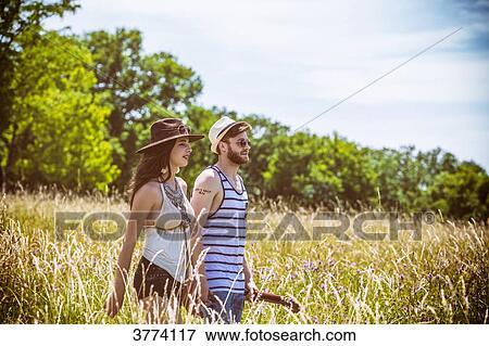 Portrait of a young couple Hipster ride in the country, holding in one hand a guitar the other View Large Photo Image Stock Photo - Portrait of a young couple Hipster ride in the country, holding in one hand a guitar the other. Fotosearch