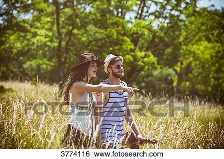 Portrait of a young couple Hipster ride in the country, holding in one hand a guitar the other View Large Photo Image Stock Photograph - Portrait of a young couple Hipster ride in the country, holding in one hand a guitar the other. Fotosearch