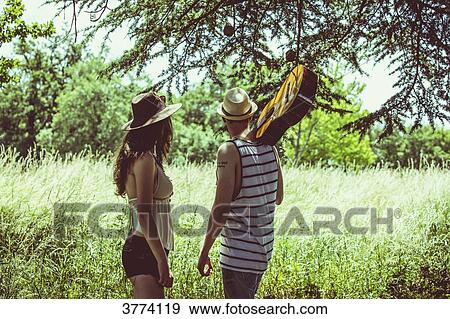 Portrait of a young couple Hipster back, a guitar over his shoulder, looking away View Large Photo Image Stock Photo - Portrait of a young couple Hipster back, a guitar over his shoulder, looking away. Fotosearch