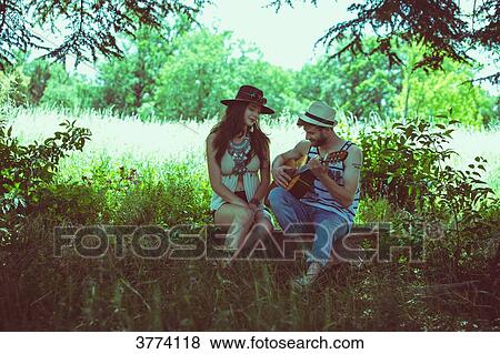 Portrait of a young couple sitting Hipster, playing guitar View Large Photo Image Stock Photo - Portrait of a young couple sitting Hipster, playing guitar. Fotosearch