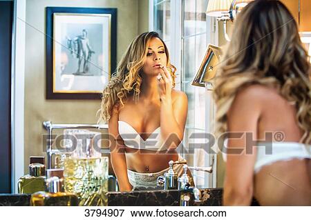 Portrait of a young face of woman in white underwear, making up in front of a mirror. View Large Photo Image Stock Photo - Portrait of a young face of woman in white underwear, making up in front of a mirror.. Fotosearch