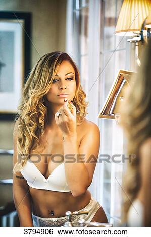 Portrait of a young face of woman in white underwear, making up in front of a mirror View Large Photo Image Stock Photograph - Portrait of a young face of woman in white underwear, making up in front of a mirror. Fotosearch