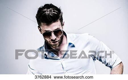 Portrait of a young man in shirt, wearing a pair of glasses, his head down View Large Photo Image Picture - Portrait of a young man in shirt, wearing a pair of glasses, his head down. Fotosearch
