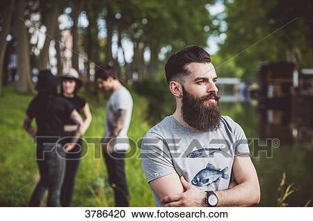 Portrait of a young man on the banks of the Garonne river barges and three people in the background View Large Photo Image Stock Image - Portrait of a young man on the banks of the Garonne river barges and three people in the background. Fotosearch
