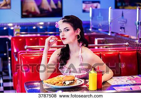 Portrait of a young Pin Up, face in profile, holding a fry from her fingertips View Large Photo Image Stock Photo - Portrait of a young Pin Up, face in profile, holding a fry from her fingertips. Fotosearch