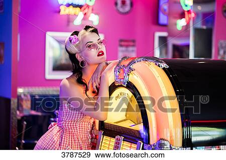 Portrait of a young Pin Up, listening to music from a jukebox, looking toward the lens View Large Photo Image Stock Photo - Portrait of a young Pin Up, listening to music from a jukebox, looking toward the lens. Fotosearch