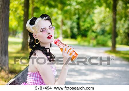 Portrait of a young Pin Up profile drinking a soda, looking toward the lens View Large Photo Image Picture - Portrait of a young Pin Up profile drinking a soda, looking toward the lens. Fotosearch