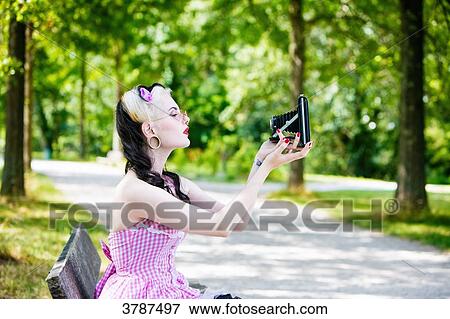 Portrait of a young Pin Up profile, taking a selfie with an old bellows camera View Large Photo Image Stock Photo - Portrait of a young Pin Up profile, taking a selfie with an old bellows camera. Fotosearch