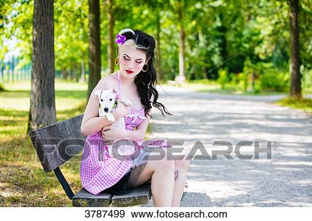Portrait of a young Pin Up profile, holding a puppy in his arms View Large Photo Image Stock Photo - Portrait of a young Pin Up profile, holding a puppy in his arms. Fotosearch
