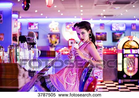 Stock Photography - Portrait of a young Pin Up profile, delicately drinking a milkshake. Fotosearch