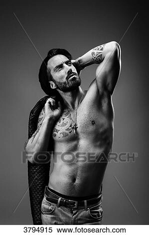 Portrait of a young tattooed man, face, face up, one arm behind his head under gray background View Large Photo Image Stock Photography - Portrait of a young tattooed man, face, face up, one arm behind his head under gray background. Fotosearch