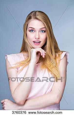 Portrait of a young woman caught with one hand under the chin View Large Photo Image Stock Photograph - Portrait of a young woman caught with one hand under the chin. Fotosearch