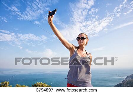 Portrait of a young woman face, taking a selfie with smartphone on the heights of Setubal, Lisbon area, Portugal View Large Photo Image Stock Photo - Portrait of a young woman face, taking a selfie with smartphone on the heights of Setubal, Lisbon area, Portugal. Fotosearch