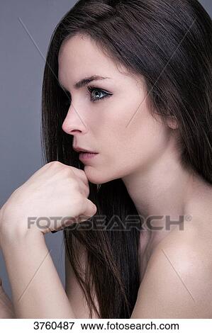 Portrait of a young woman in profile, hand under chin, looking toward the lens View Large Photo Image Stock Photo - Portrait of a young woman in profile, hand under chin, looking toward the lens. Fotosearch