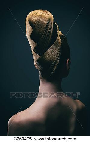 Stock Photography - Portrait of a young woman wearing a bun, back. Fotosearch