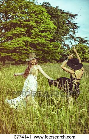 Portrait of two girls dancing in a field View Large Photo Image Stock Image - Portrait of two girls dancing in a field. Fotosearch