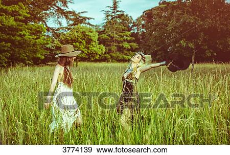 Portrait of two girls dancing in a field View Large Photo Image Stock Photo - Portrait of two girls dancing in a field. Fotosearch