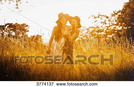 Portrait of two girls having fun in a field View Large Photo Image Stock Photo - Portrait of two girls having fun in a field. Fotosearch