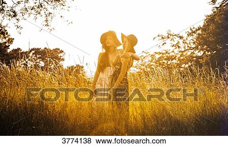Portrait of two young girls in a field, looking into the distance View Large Photo Image Stock Photo - Portrait of two young girls in a field, looking into the distance. Fotosearch