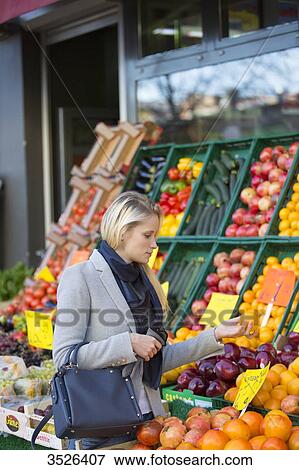 Pretty blonde woman buying healthy food on the market View Large Photo Image Stock Photo - Pretty blonde woman buying healthy food on the market. Fotosearch