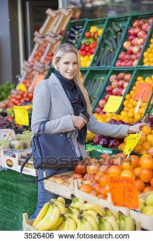 Pretty blonde woman buying healthy food on the market and smiling at camera View Large Photo Image Stock Photograph - Pretty blonde woman buying healthy food on the market and smiling at camera. Fotosearch
