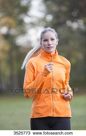 Pretty blonde woman doing jogging in park View Large Photo Image Stock Image - Pretty blonde woman doing jogging in park. Fotosearch