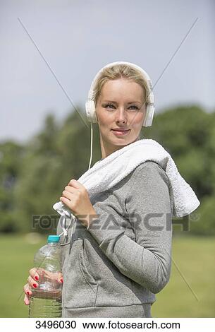 Stock Image - Pretty blonde woman doing sport in park. Fotosearch