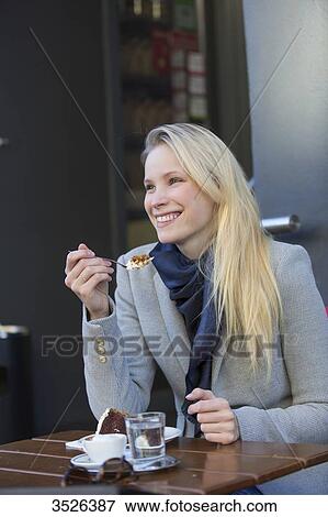 Pretty blonde woman enjoying a cake and coffee in city center View Large Photo Image Stock Photo - Pretty blonde woman enjoying a cake and coffee in city center. Fotosearch