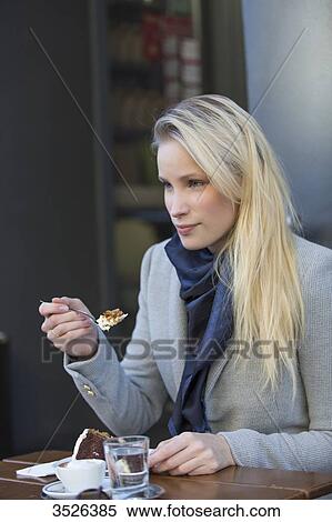 Pretty blonde woman enjoying a cake and coffee in city center View Large Photo Image Stock Photography - Pretty blonde woman enjoying a cake and coffee in city center. Fotosearch