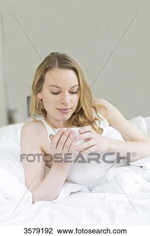 Pretty blonde woman enjoying a tea in bed View Large Photo Image Stock Image - Pretty blonde woman enjoying a tea in bed. Fotosearch